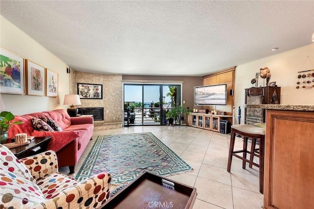 tiled living room featuring a fireplace and a textured ceiling