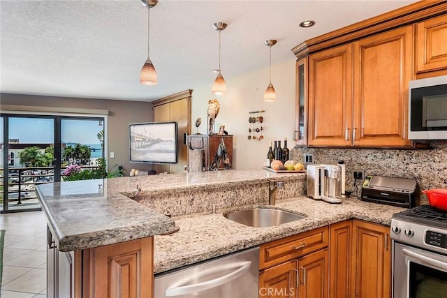 kitchen with appliances with stainless steel finishes, tasteful backsplash, light tile patterned flooring, hanging light fixtures, and sink