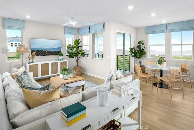 living room featuring ceiling fan and light hardwood / wood-style floors