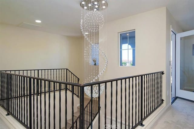 corridor with carpet floors and a chandelier