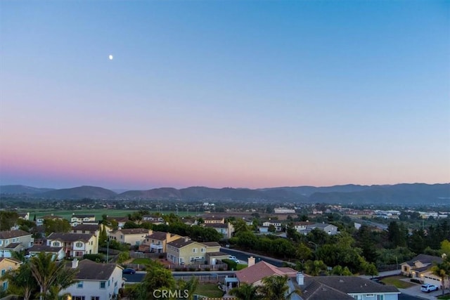 aerial view at dusk featuring a mountain view