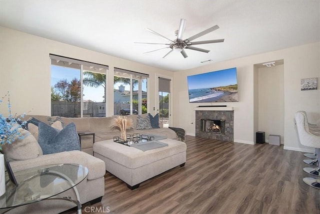 living room featuring a fireplace, hardwood / wood-style flooring, and ceiling fan