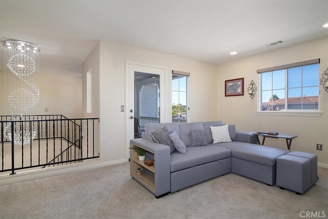 carpeted living room with a notable chandelier