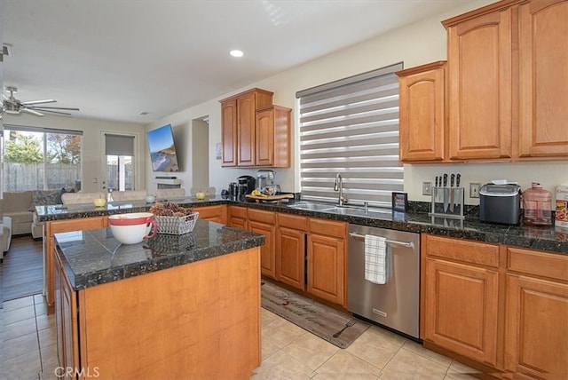 kitchen with sink, stainless steel dishwasher, ceiling fan, light tile patterned floors, and a kitchen island