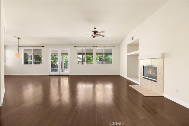 unfurnished living room featuring ceiling fan, a fireplace, and dark wood-type flooring