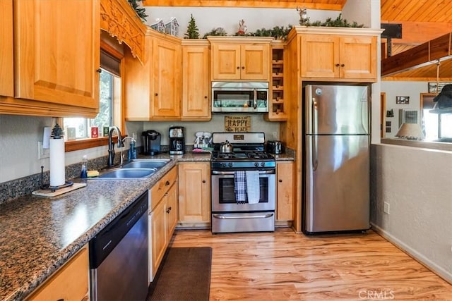 kitchen with sink, stainless steel appliances, dark stone countertops, wood ceiling, and light wood-type flooring