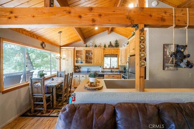 kitchen featuring vaulted ceiling with beams, decorative light fixtures, wooden ceiling, and light hardwood / wood-style flooring