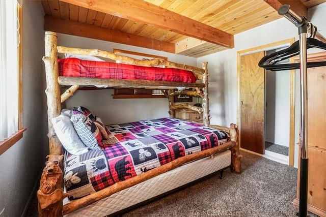 bedroom featuring carpet flooring, beamed ceiling, and wooden ceiling