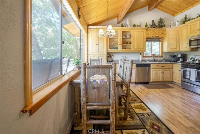 kitchen with stainless steel appliances, vaulted ceiling with beams, light hardwood / wood-style flooring, a chandelier, and decorative light fixtures