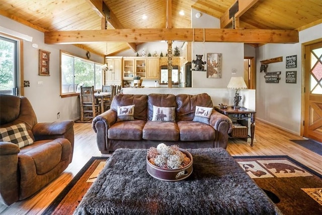 living room with vaulted ceiling with beams, a healthy amount of sunlight, and light wood-type flooring