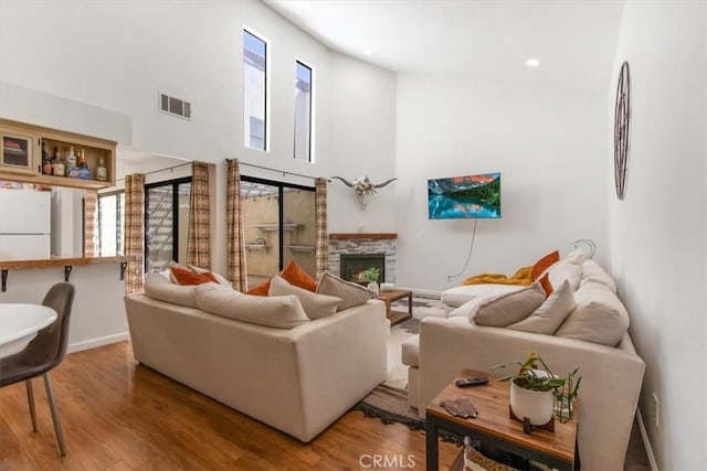 43334 32nd St W Unit 44, Lancaster, CA 93536 - living room with wood finished floors, a towering ceiling, a stone fireplace, and recessed lighting