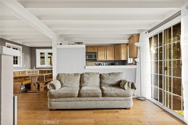 living room featuring light hardwood / wood-style flooring and beamed ceiling