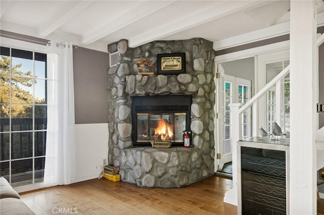 living room with hardwood / wood-style flooring, beverage cooler, a fireplace, and beamed ceiling