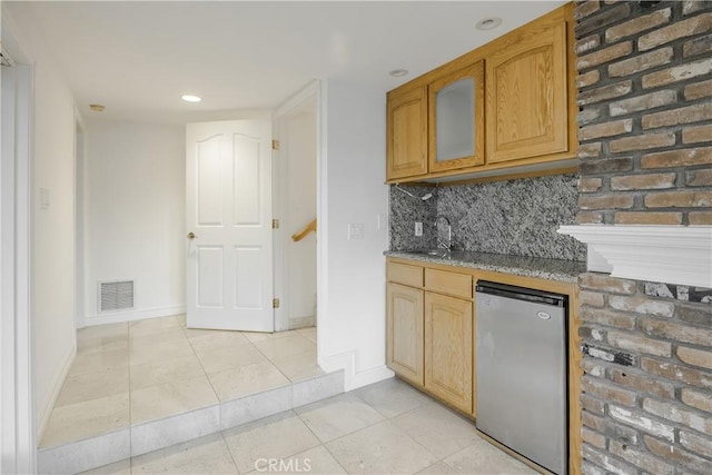 kitchen featuring light tile patterned floors, sink, decorative backsplash, and stainless steel fridge