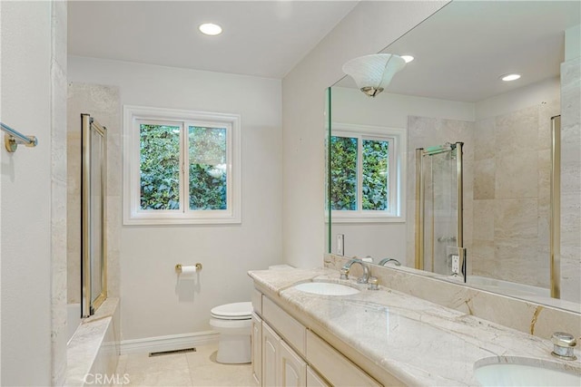 bathroom with vanity, toilet, tile patterned floors, and a shower with door