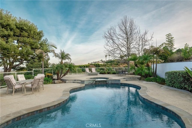 view of swimming pool featuring a patio area and an in ground hot tub