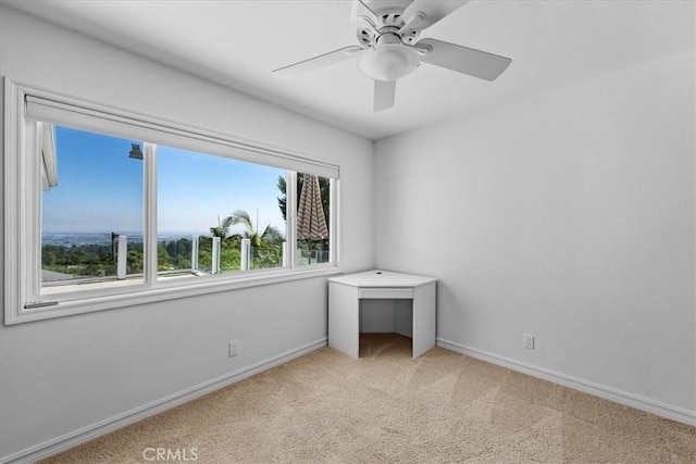 unfurnished bedroom featuring multiple windows, light colored carpet, and ceiling fan