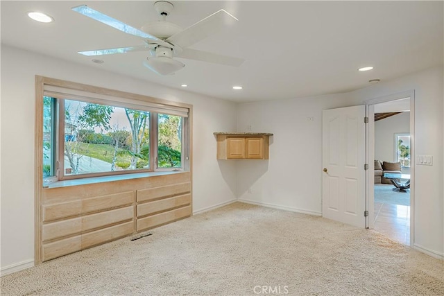 carpeted spare room with ceiling fan