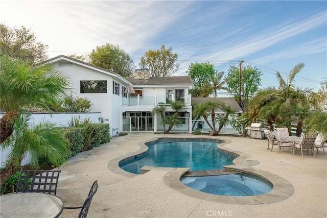 view of swimming pool with an in ground hot tub, a patio area, and grilling area