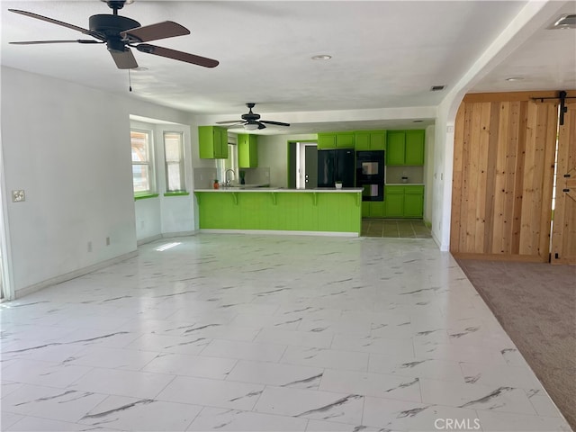 unfurnished living room featuring light carpet, ceiling fan, and sink