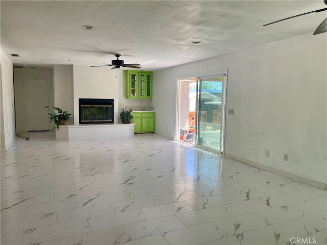 unfurnished living room featuring sink and ceiling fan