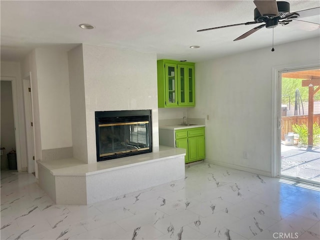 unfurnished living room featuring ceiling fan and sink