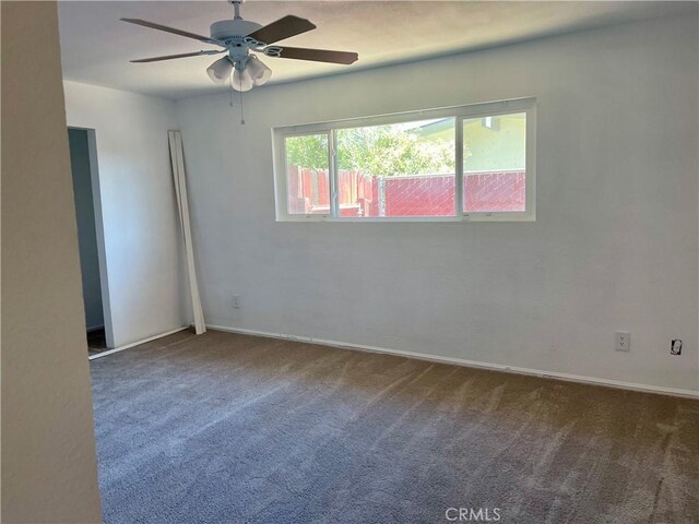 carpeted spare room featuring ceiling fan