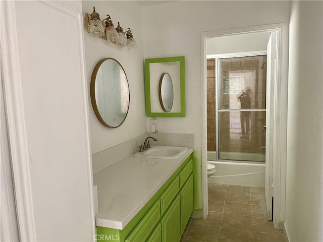 full bathroom featuring tile patterned flooring, enclosed tub / shower combo, vanity, and toilet