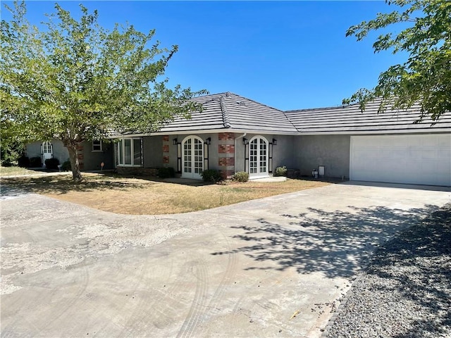 single story home featuring a garage and french doors