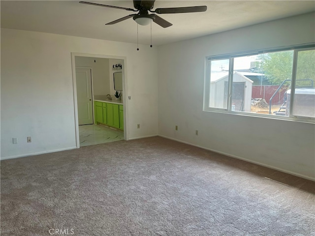 carpeted spare room featuring sink and ceiling fan