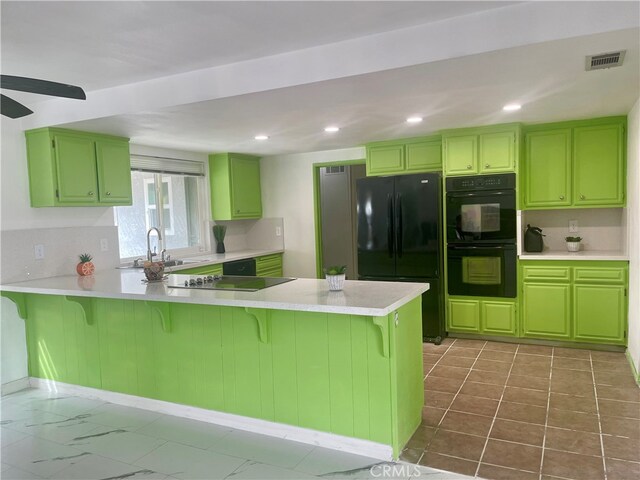 kitchen featuring a breakfast bar area, sink, kitchen peninsula, black appliances, and ceiling fan