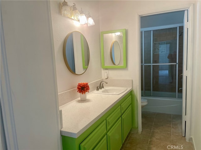 full bathroom featuring enclosed tub / shower combo, vanity, toilet, and tile patterned floors