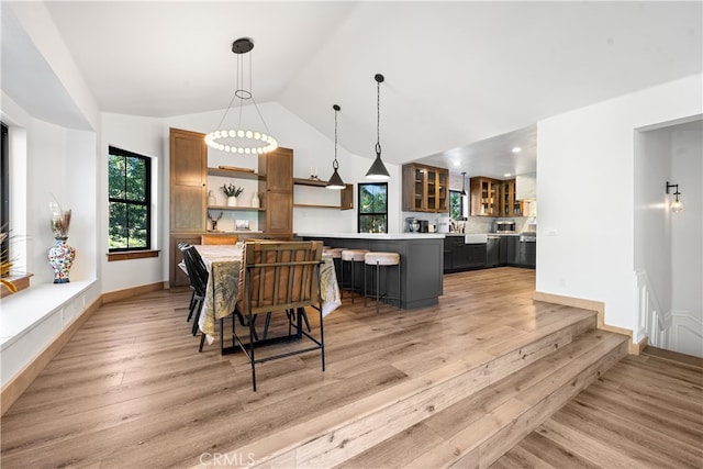 dining space with lofted ceiling and light wood-type flooring