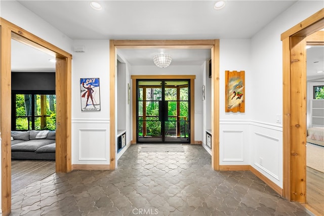 entrance foyer with a wealth of natural light, an inviting chandelier, and dark hardwood / wood-style flooring