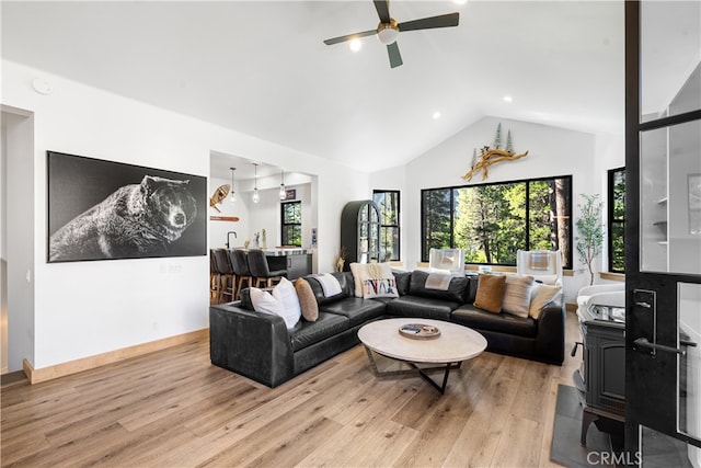 living room featuring light wood-type flooring, high vaulted ceiling, and ceiling fan