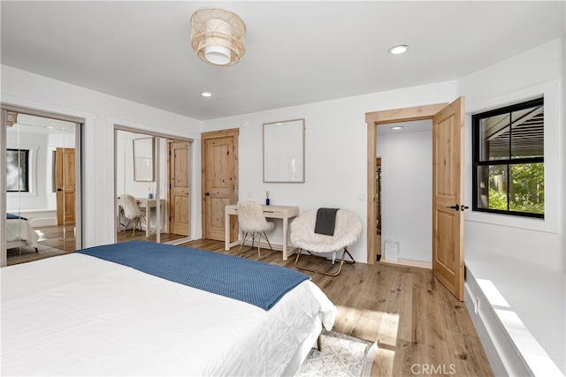 bedroom featuring ensuite bath and light hardwood / wood-style floors