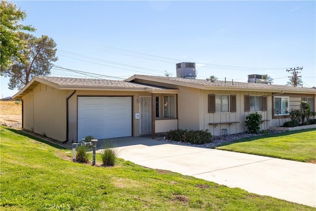 ranch-style home with cooling unit, a front yard, and a garage