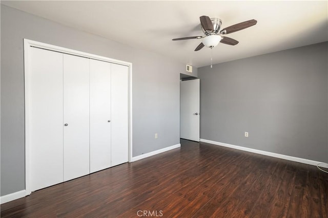 unfurnished bedroom featuring a closet, ceiling fan, and dark wood-type flooring