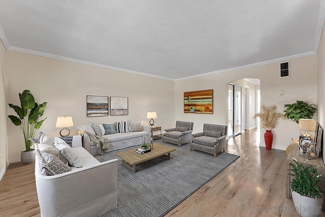 living room featuring crown molding and light hardwood / wood-style floors