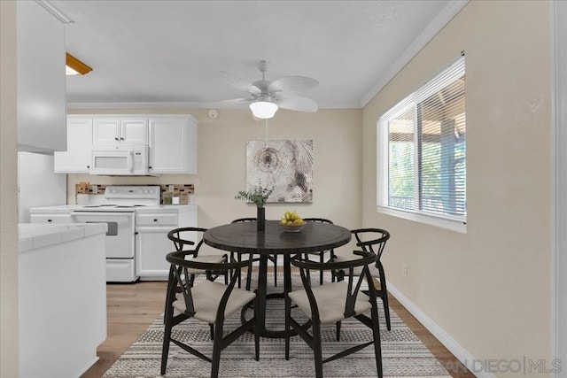 dining space with ornamental molding, hardwood / wood-style floors, and ceiling fan