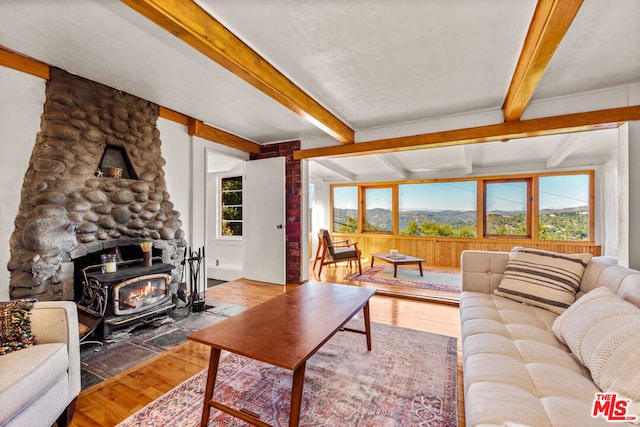 living room with hardwood / wood-style floors, a wealth of natural light, and beamed ceiling