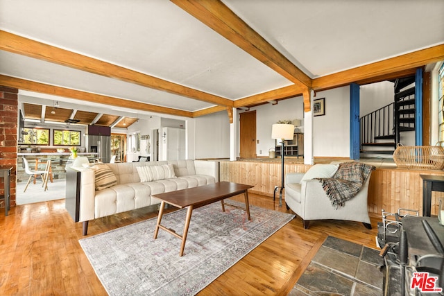 living room featuring beamed ceiling and wood-type flooring