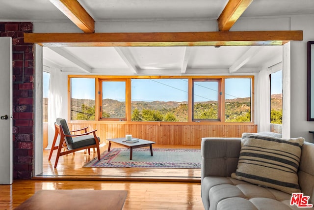 sunroom / solarium featuring a mountain view and beam ceiling