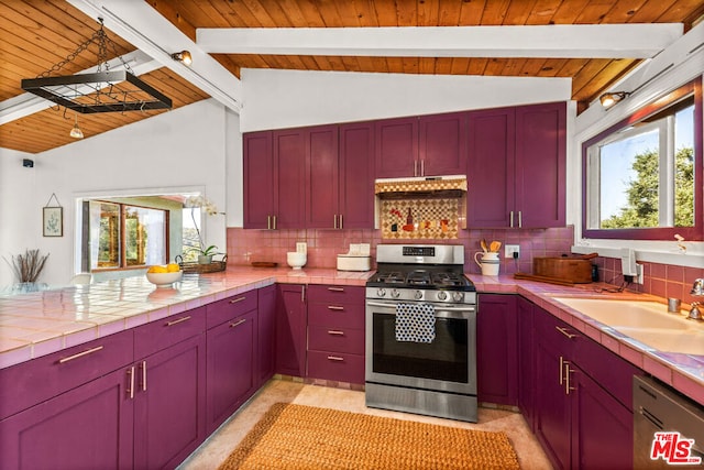 kitchen featuring sink, tile countertops, a wealth of natural light, stainless steel appliances, and decorative backsplash