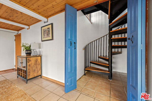 stairs featuring tile patterned flooring, wood ceiling, and beamed ceiling