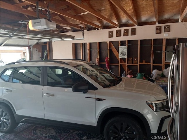 garage featuring stainless steel fridge and a garage door opener