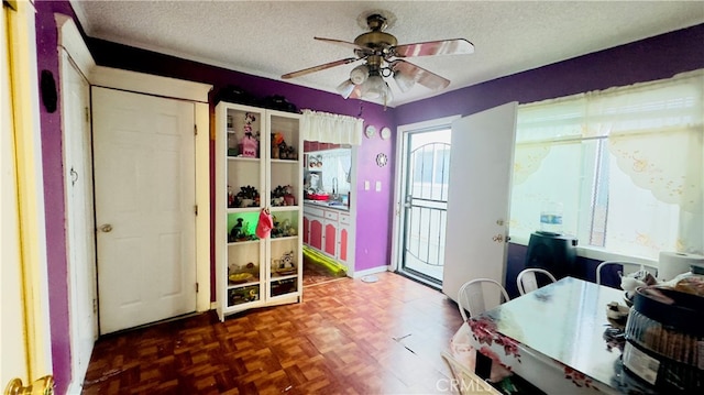 office space with dark parquet floors, ceiling fan, and a textured ceiling