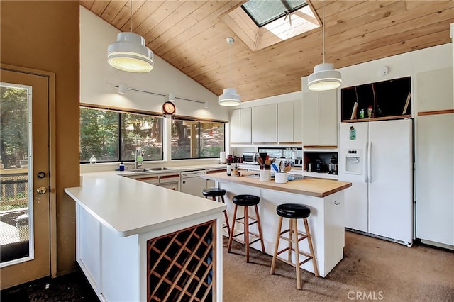 kitchen with white cabinets, white appliances, a kitchen island, wooden ceiling, and a skylight