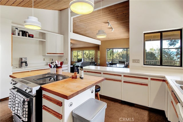 kitchen featuring hanging light fixtures, white cabinetry, high end stainless steel range oven, wooden ceiling, and dark colored carpet