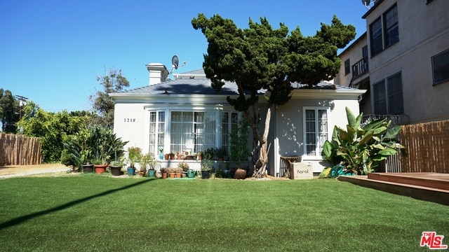 rear view of property featuring a lawn